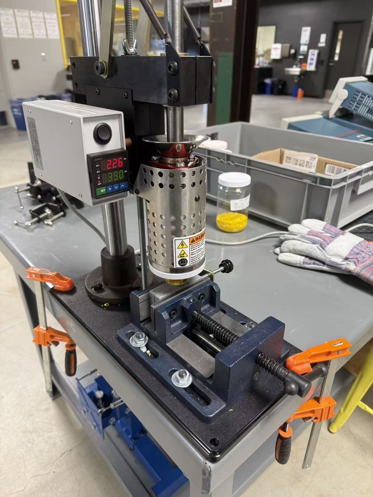 Desktop injection molding machine clamped to workbench